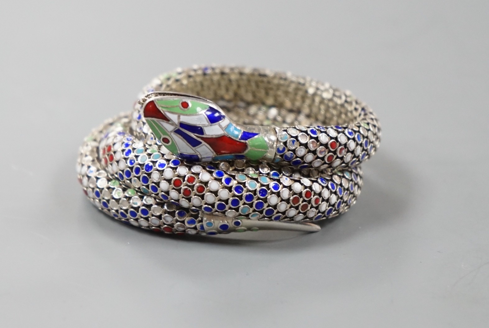 A continental 935 white metal and polychrome enamel set coiled serpent bangle.